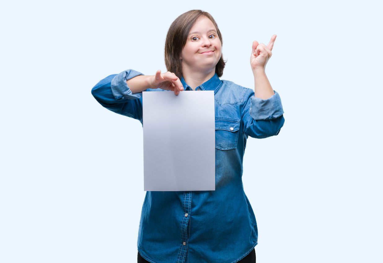 Young adult woman with Down syndrome holding blank paper
